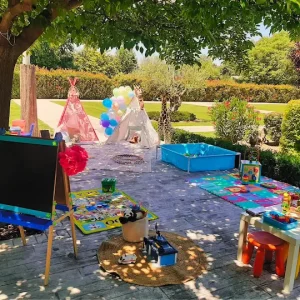 Espacio infantil con diversos juegos y juguetes al aire libre dentro de una boda
